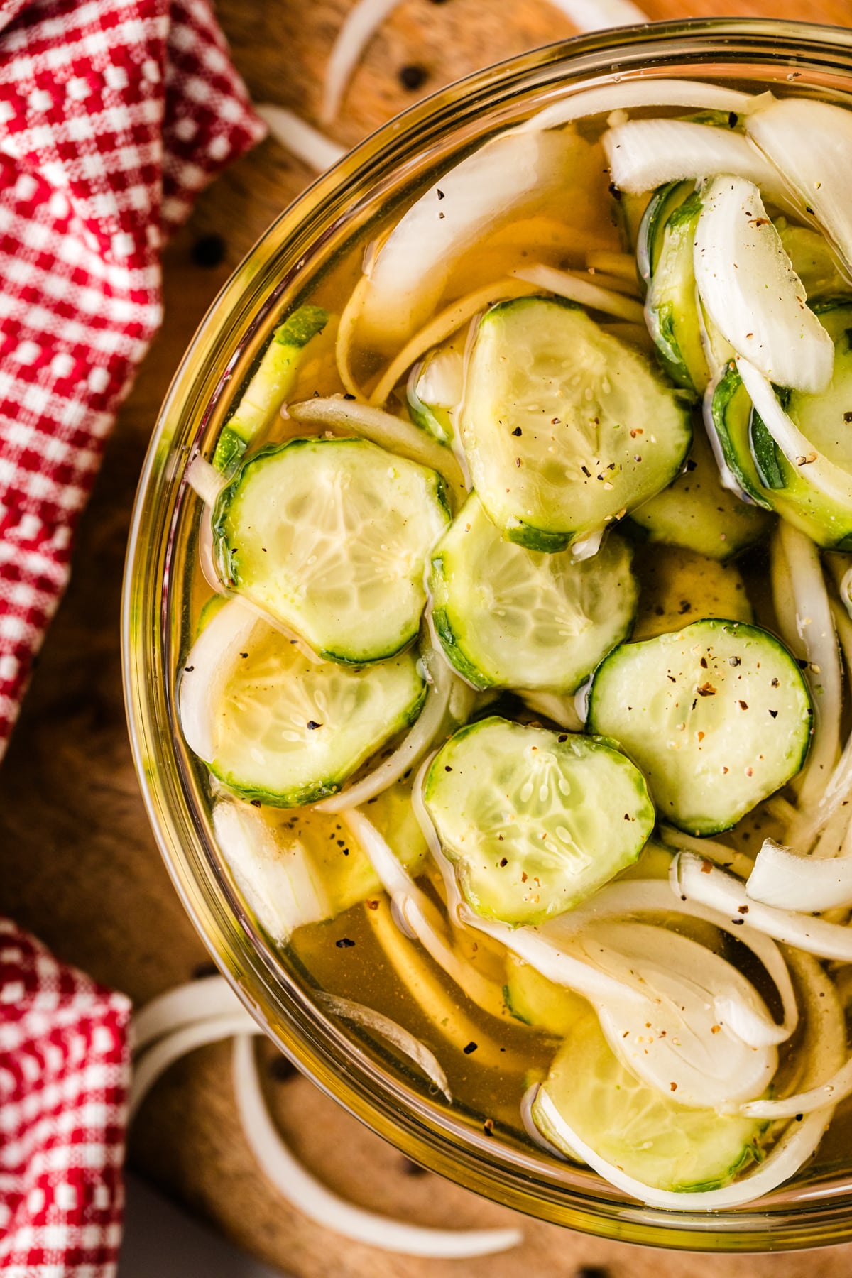 Homemade refrigerator pickles 7 with sliced cucumbers and onions in a glass jar with brine and black pepper