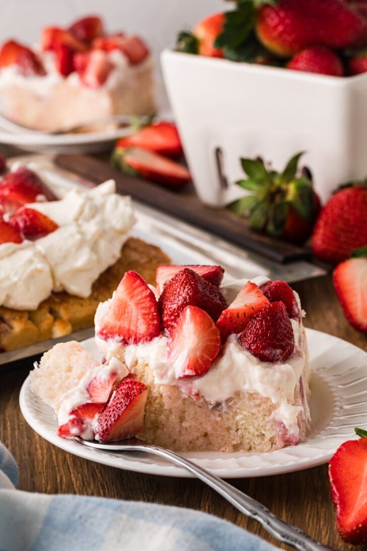 Slice of strawberry shortcake on white plate with whipped cream and fresh berries for Mother's Day Brunch Recipes