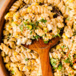 Mexican Street Corn Pasta Salad in wooden bowl with wooden spoon, topped with fresh cilantro and corn kernels