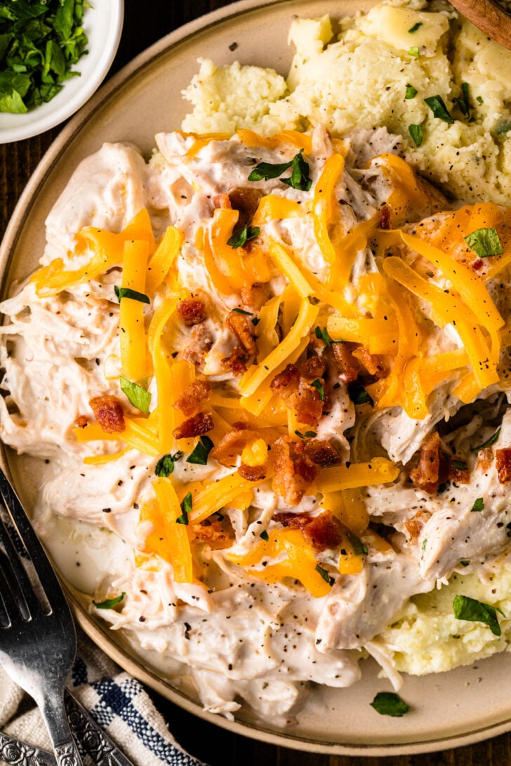 Tender Crock Pot Creamy Ranch Chicken served over mashed potatoes with fresh parsley, a cozy slow cooker dinner with no cream-of soup.