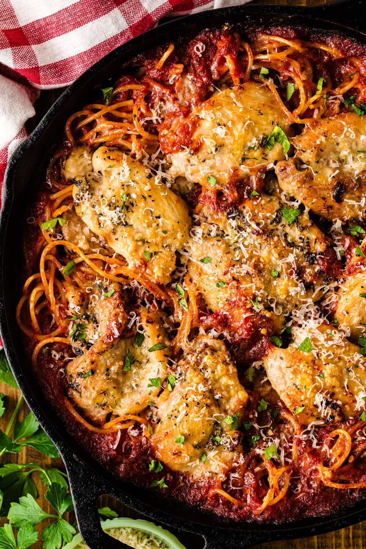 Skillet chicken spaghetti 9 in cast iron with crispy golden chicken, red sauce, crispy onion strings, grated cheese, and fresh parsley garni