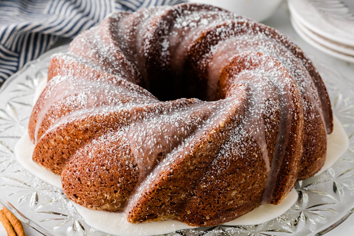 Spice cake with cream cheese frosting sliced to show the moist cinnamon-spiced layers.