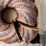 Overhead view of sliced spice cake 9 dusted with powdered sugar on a decorative white plate with blue-striped napkin