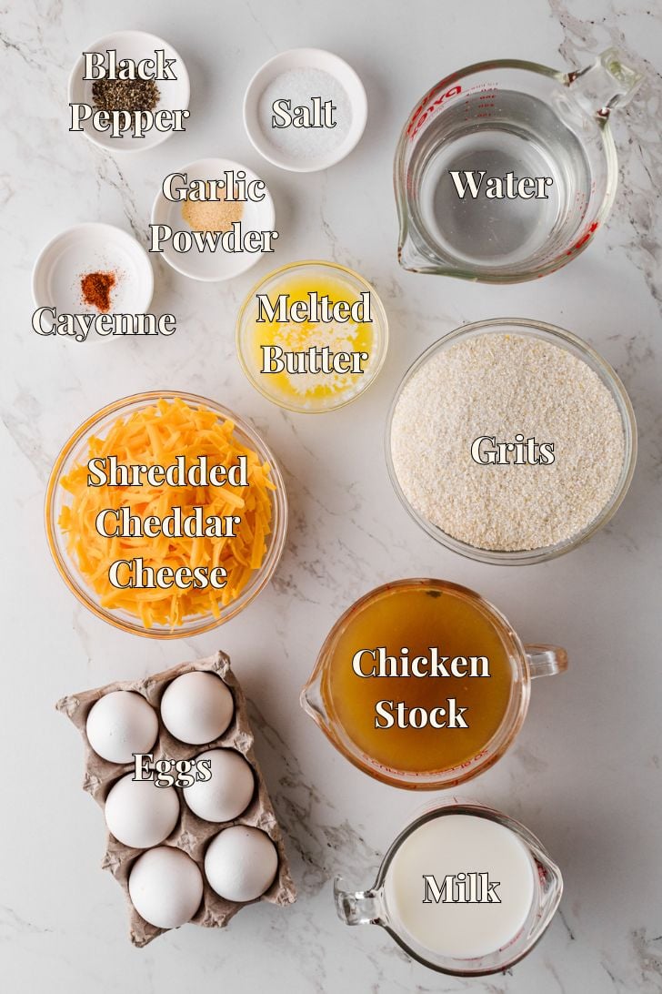 Ingredients for baked cheese grits laid out on a counter, including grits, eggs, cheese, milk, and butter for an easy Southern casserole.