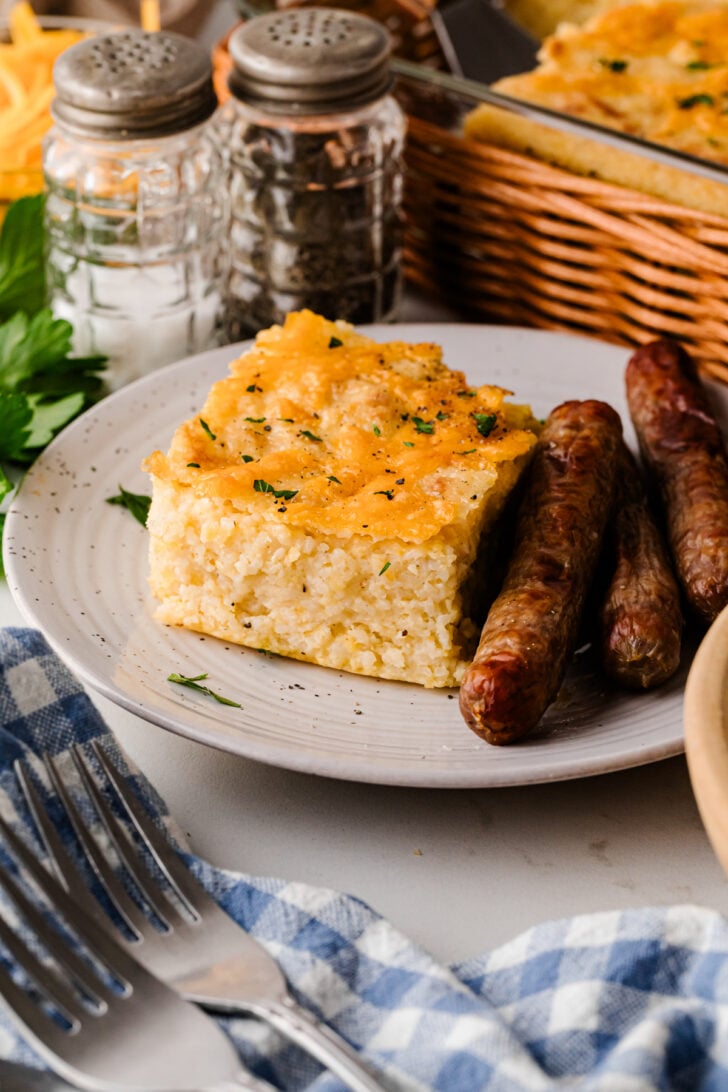 Baked cheese grits casserole in a white dish with a golden, bubbly top - a classic Southern make‑ahead side dish for holidays and brunch.
