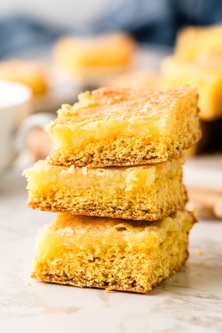 Stacked squares of Neiman Marcus Cake on a small plate, showing the soft, moist inside and lightly crisp edges, ready to serve with coffee.