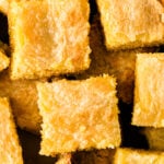Golden Neiman Marcus Cake squares stacked closely together, showing rich, moist crumb texture and caramel-colored frosting topping