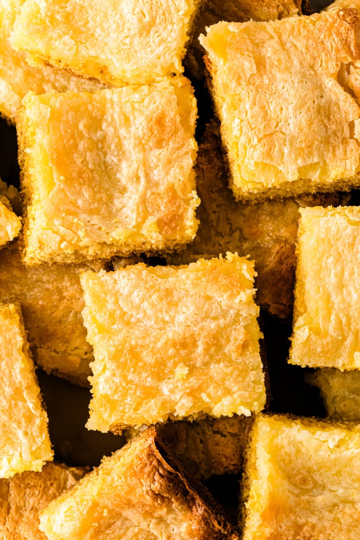 Squares of Neiman Marcus Cake cut from the pan, showing the soft yellow cake and rich, tender crumb.