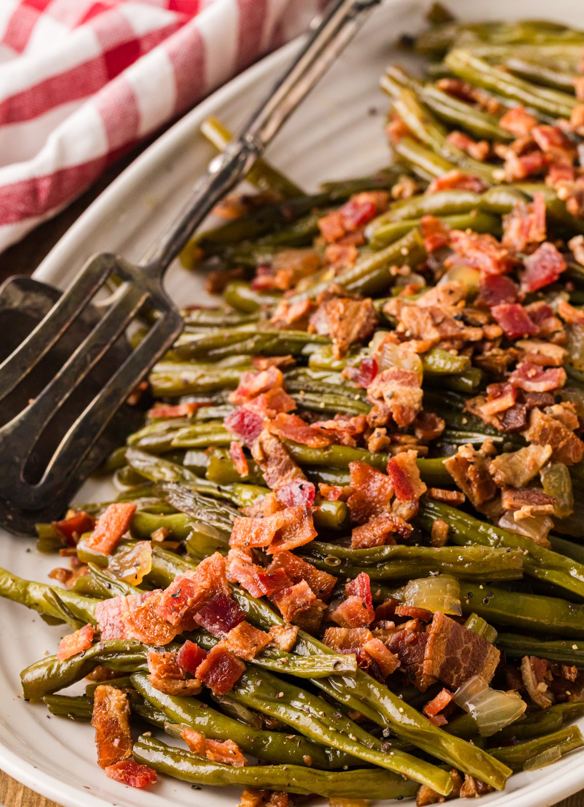 Crispy bacon-topped green beans on white plate with fork, cp maple greenbeans 14 side dish recipe