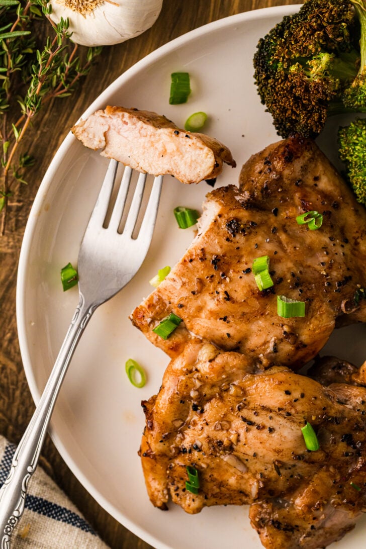 Sliced balsamic chicken thighs close up showing a deeply caramelized, glazed surface with pooling balsamic reduction.