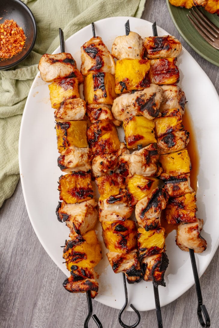 Grilled Hawaiian chicken and pineapple skewers on a plate.