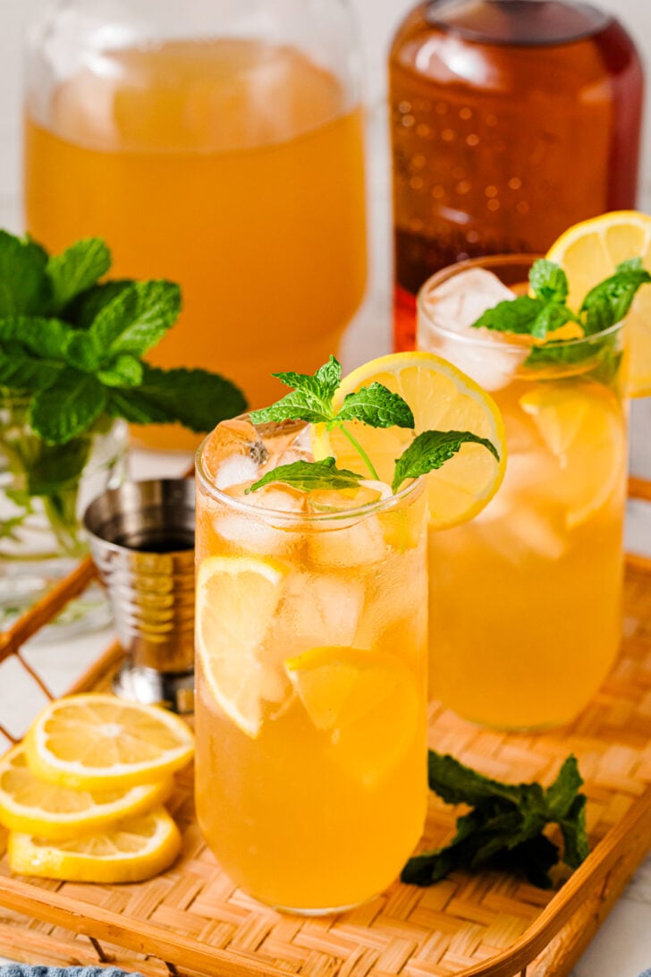 Bourbon Arnold Palmer cocktails garnished with lemon and mint.
