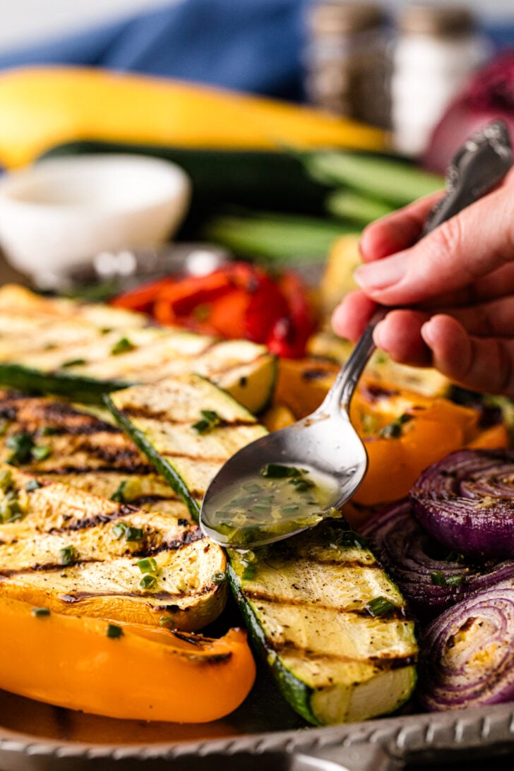 Drizzling chive dressing over grilled zucchini, peppers, and onions.